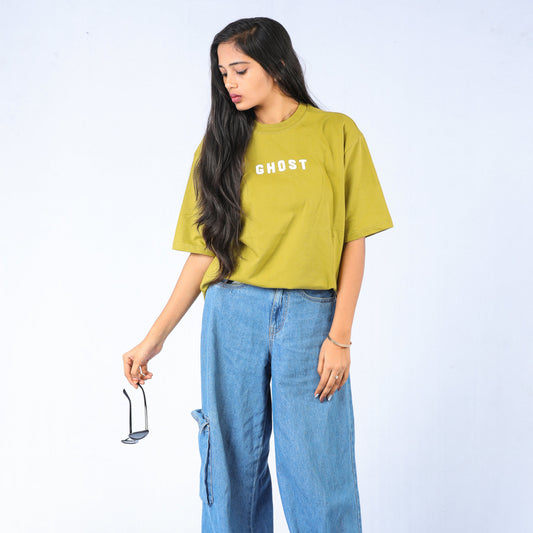 Woman wearing a yellow t-shirt with 'GHOST' text and blue jeans on a white background